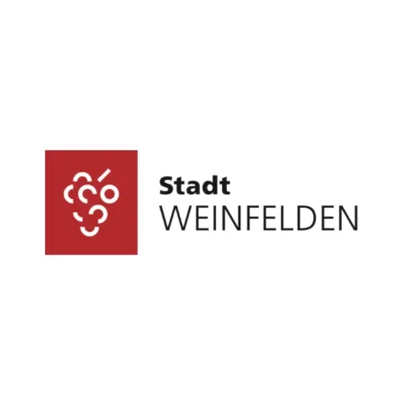 Das logo der stadt weinfelden ist ein rotes quadrat mit einer traube darauf.