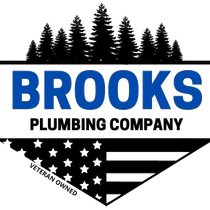 Logo for Brooks Plumbing Company, featuring a blue text on a white backdrop, with a silhouette of trees above, and an American flag below.