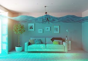 Living room flooded with water. A couch, plant, and pictures on the wall are partially submerged.