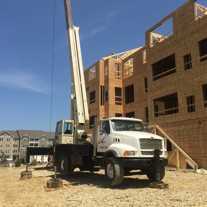 A white truck is parked in front of a building under construction