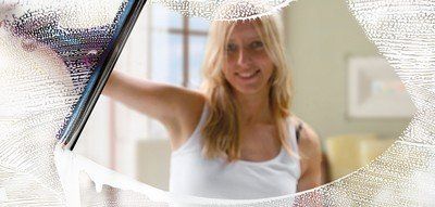 person cleaning window and smiling