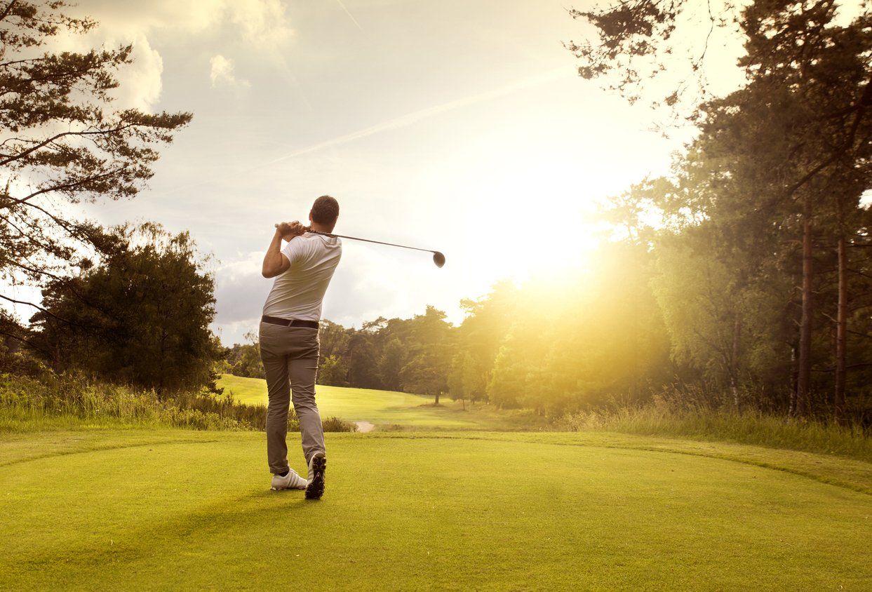 a man is swinging a golf club on a golf course .