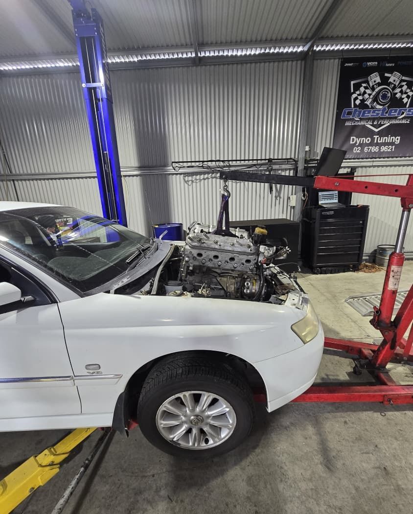White Car in a Garage With Engine Being Lifted — Chester's Mechanical & Performance in Tamworth, NSW