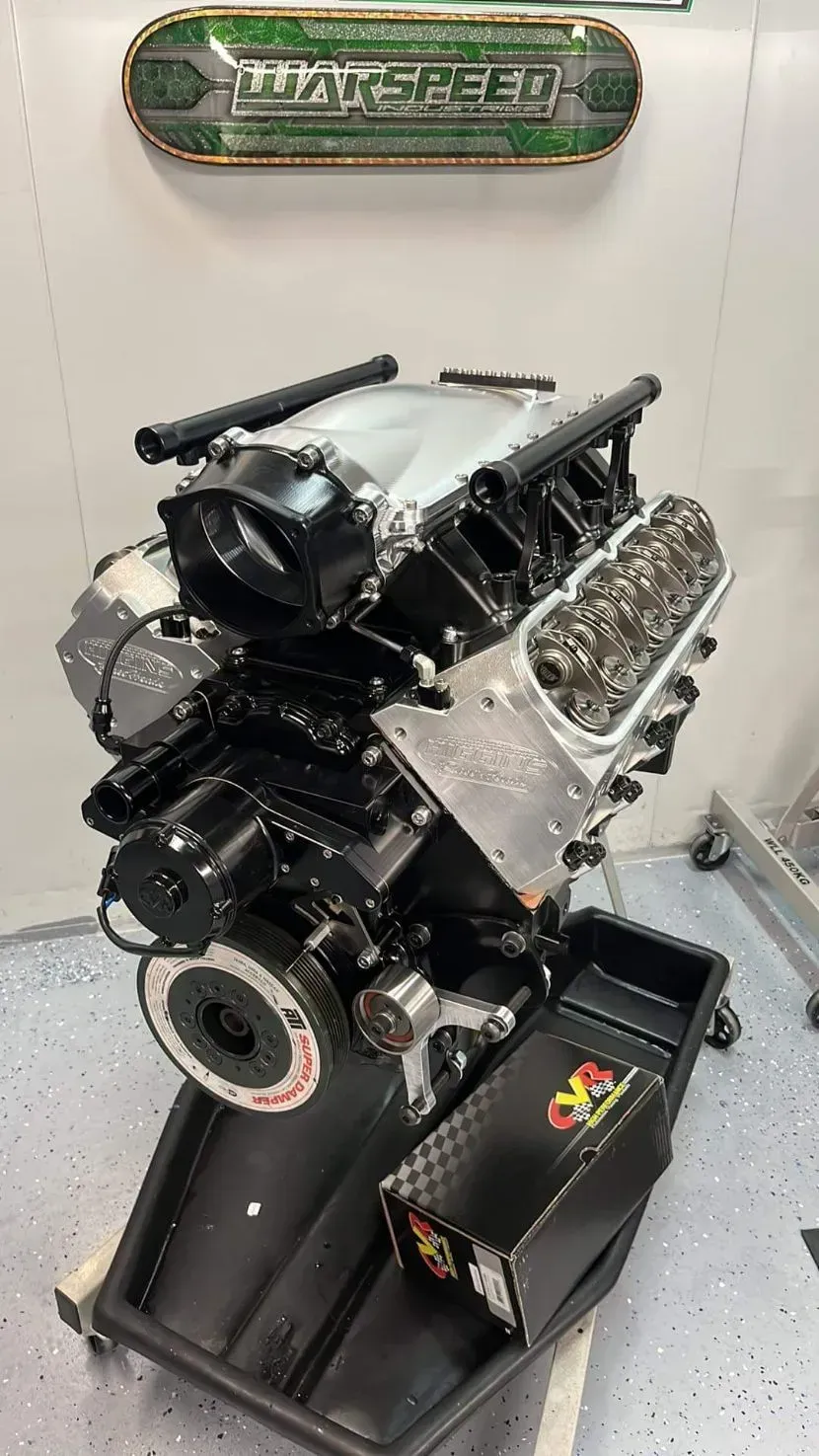 Black and Silver Race Car Engine on a Stand, Under a Maxspeed Sign — Chester's Mechanical & Performance in Tamworth, NSW