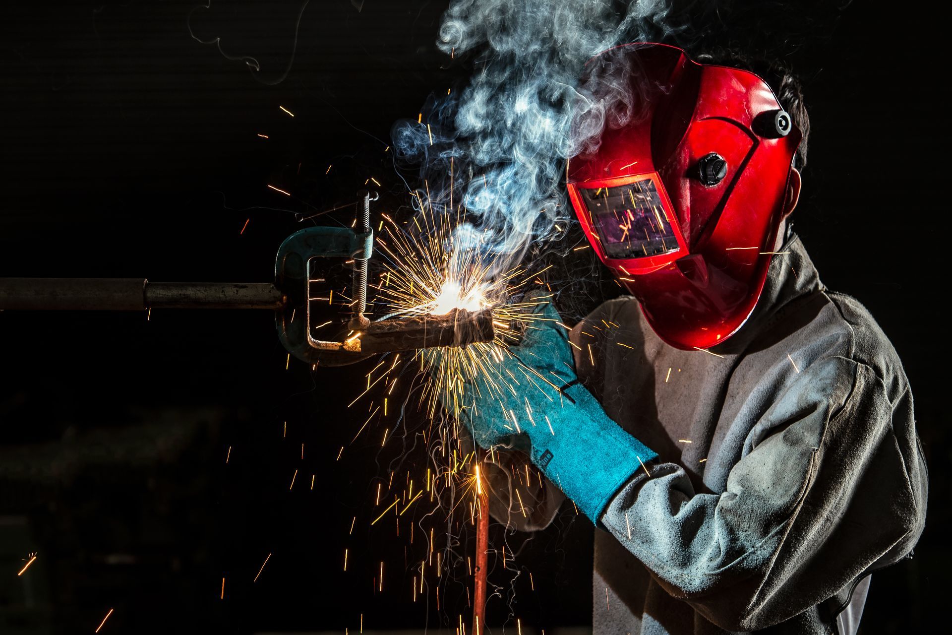 Welder working with steel in industry with safety mask