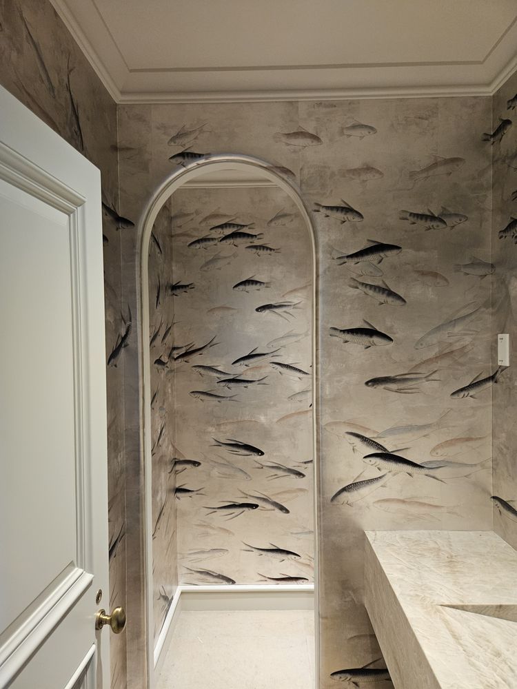 A bathroom with a fish wallpaper on the wall and a sink.