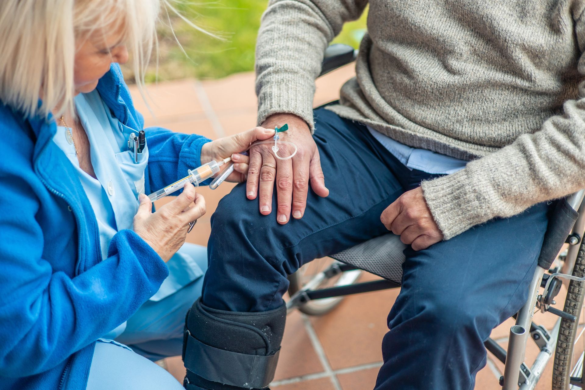 Medical professional injecting a syringe into a patient's hand with a cupping jar.