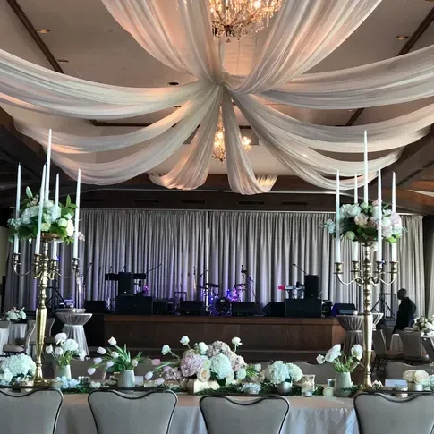 A large room with tables and chairs and candles hanging from the ceiling