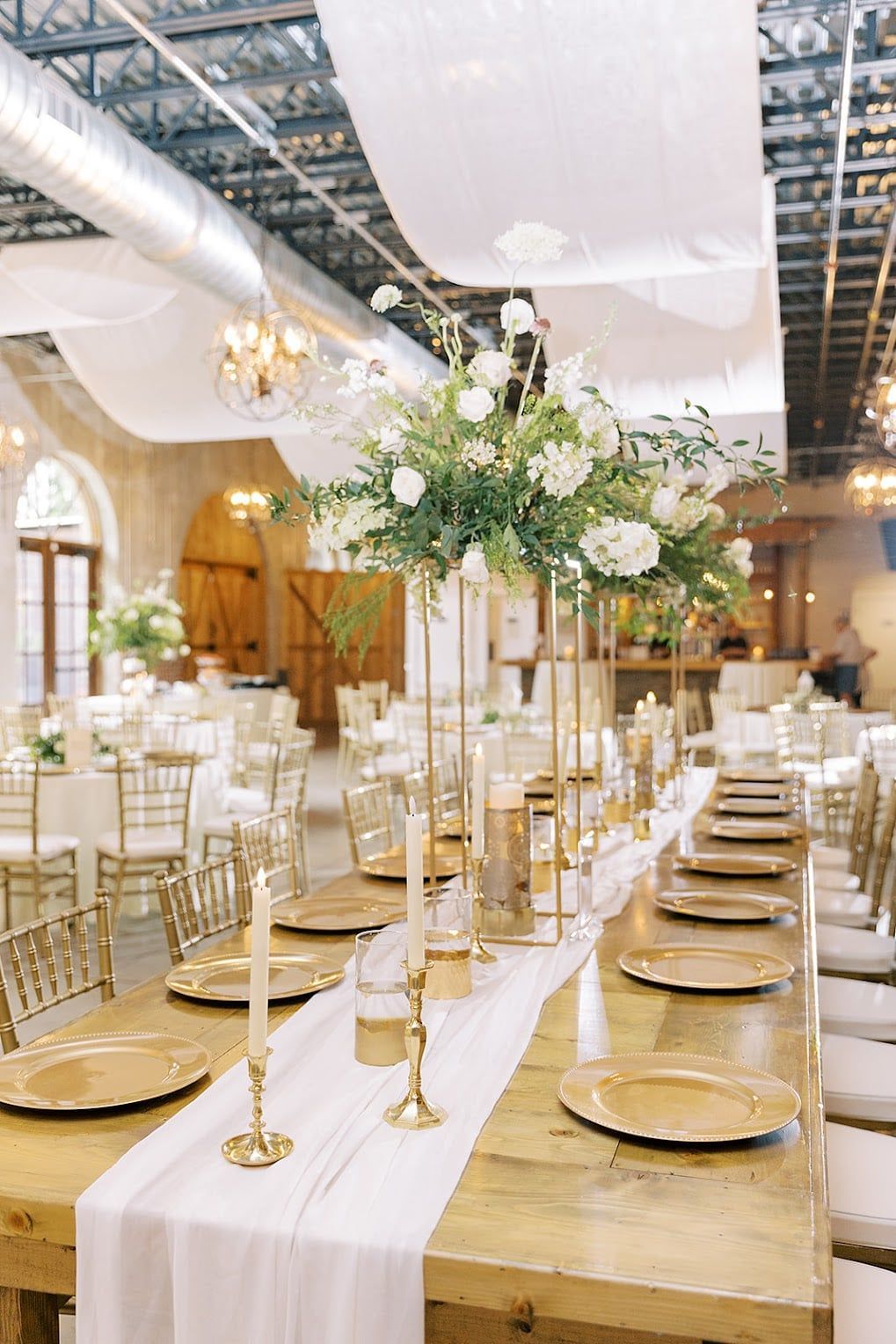 A long table with plates , candles , and flowers on it.