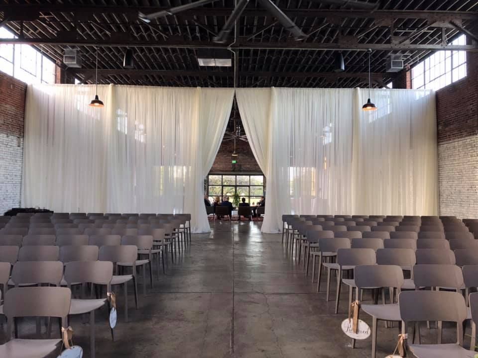A large room with rows of chairs and a white curtain.