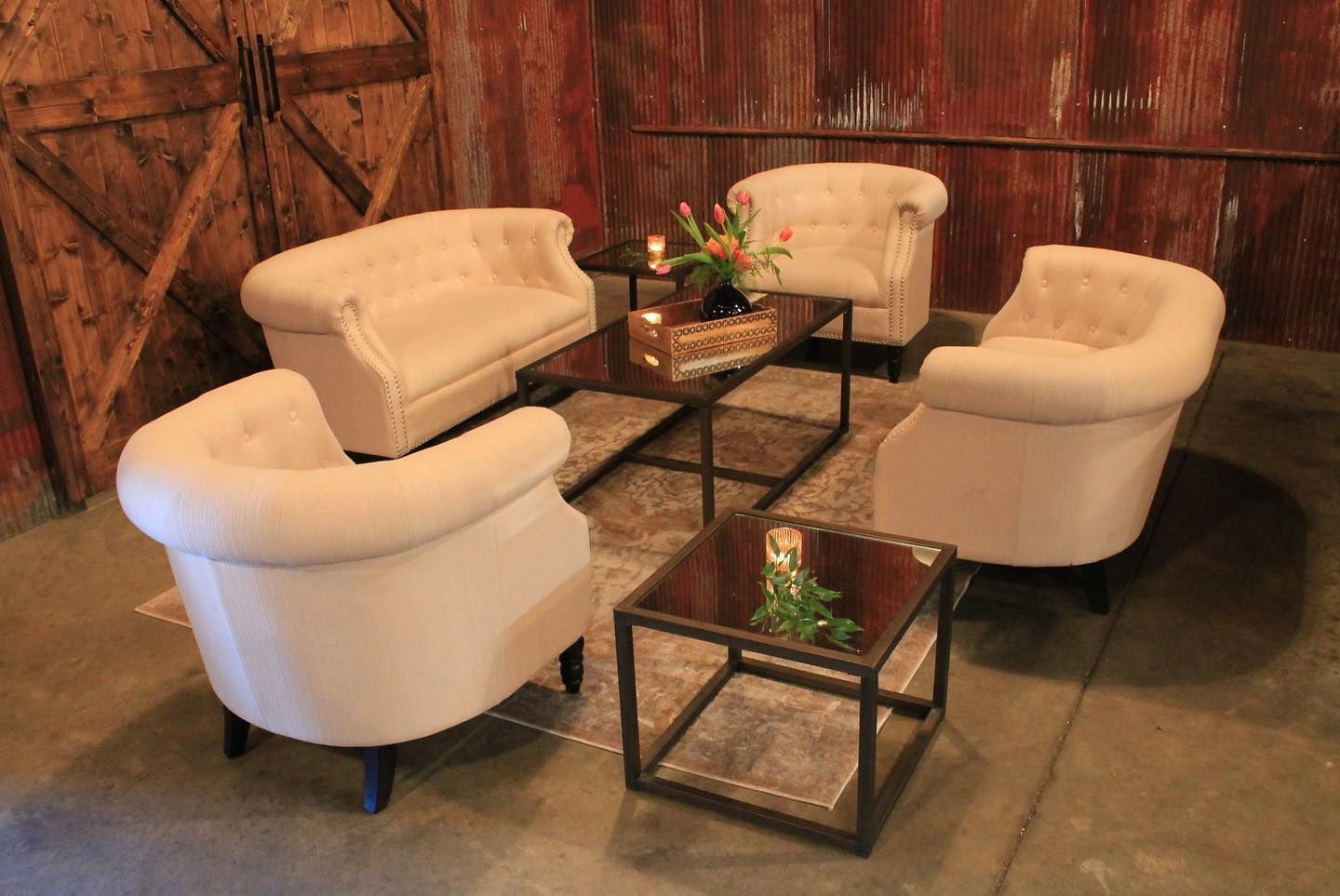 A living room with a couch , chairs , and a table.