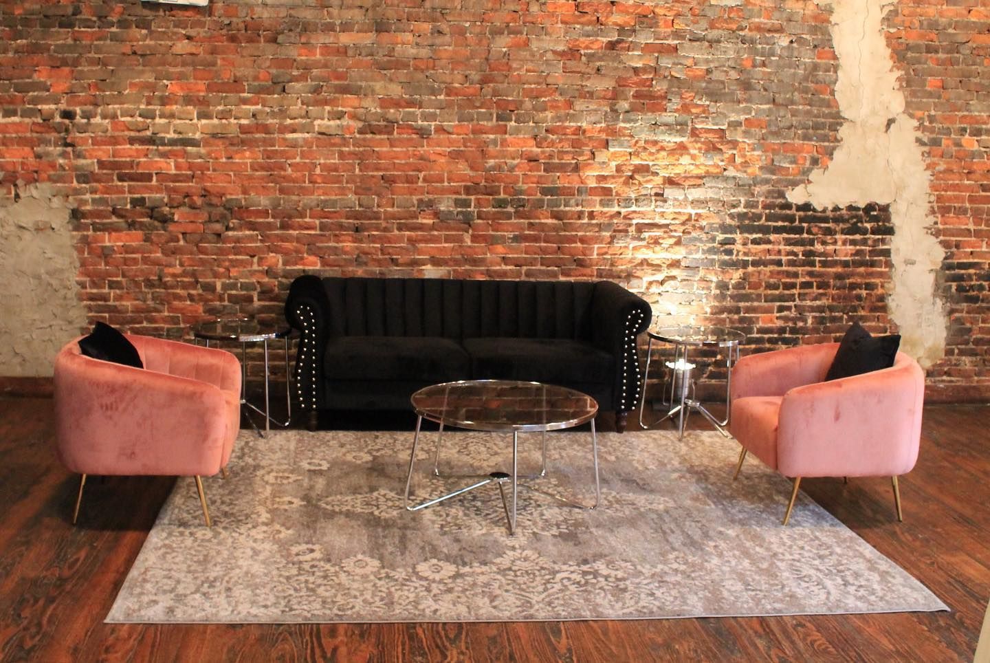 A living room with a couch , two chairs , a table and a rug.
