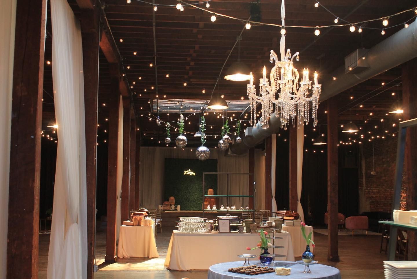A large room with tables and a chandelier hanging from the ceiling