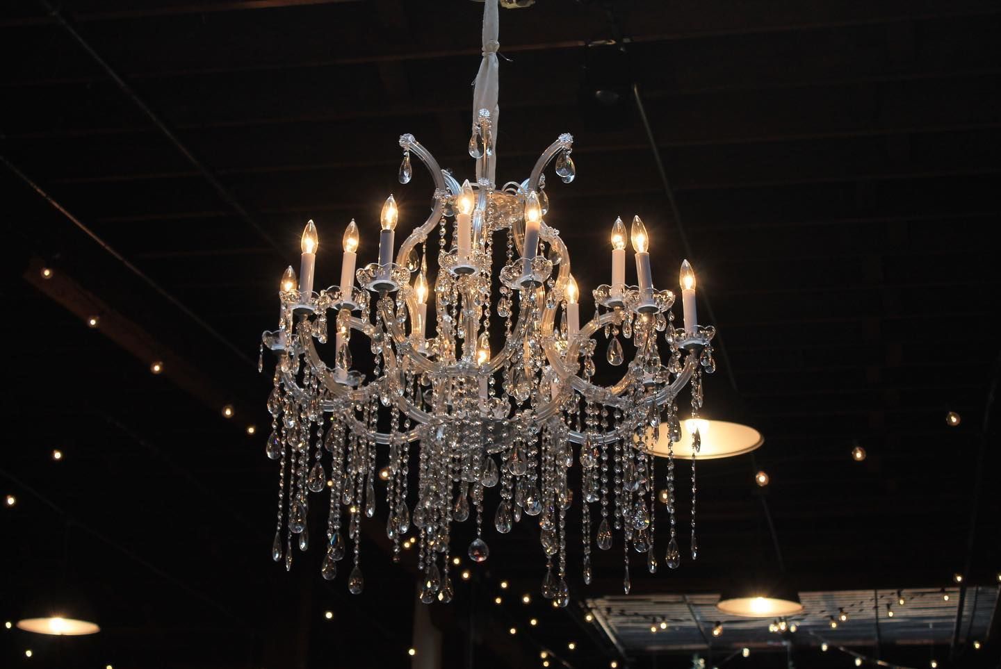 A large chandelier is hanging from the ceiling in a dark room