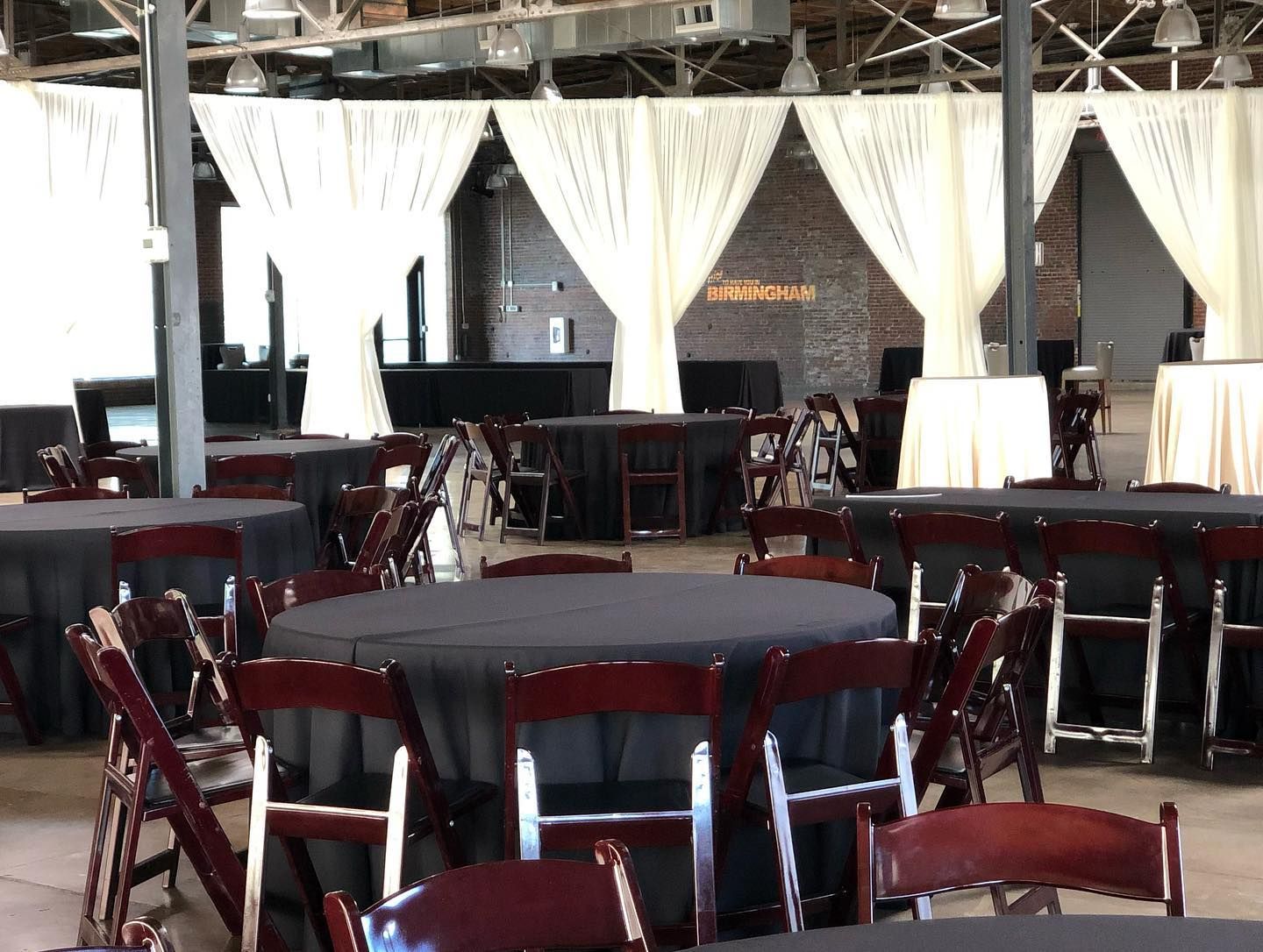 A large room with tables and chairs set up for a party
