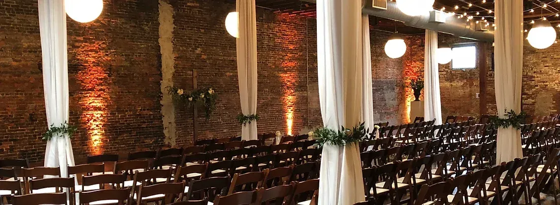 A row of wooden chairs are lined up in a church.