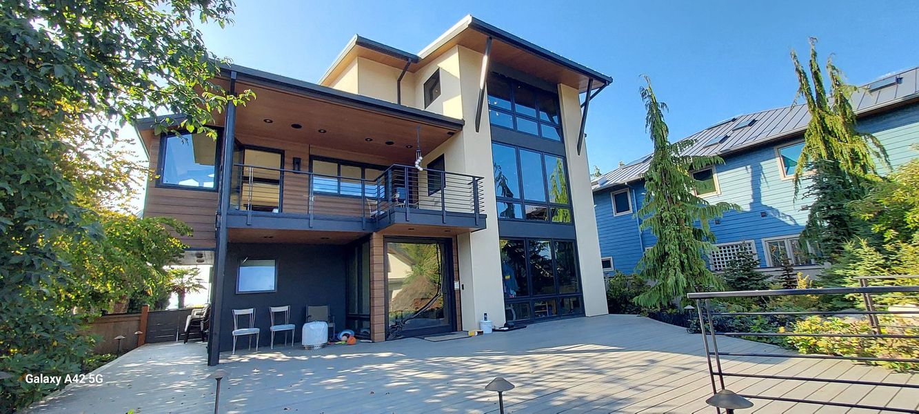 A driveway being cleaned with a pressure washer. A machine is on the concrete with a hose and water spraying.