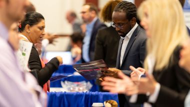 Conference attendees interacting with vendors at an expo
