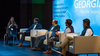Panelists sitting in chairs on the Georgia Bio 2023 Summit main stage
