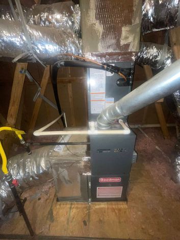A furnace is sitting in the attic of a house.