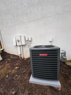 A large air conditioner is sitting outside of a building.