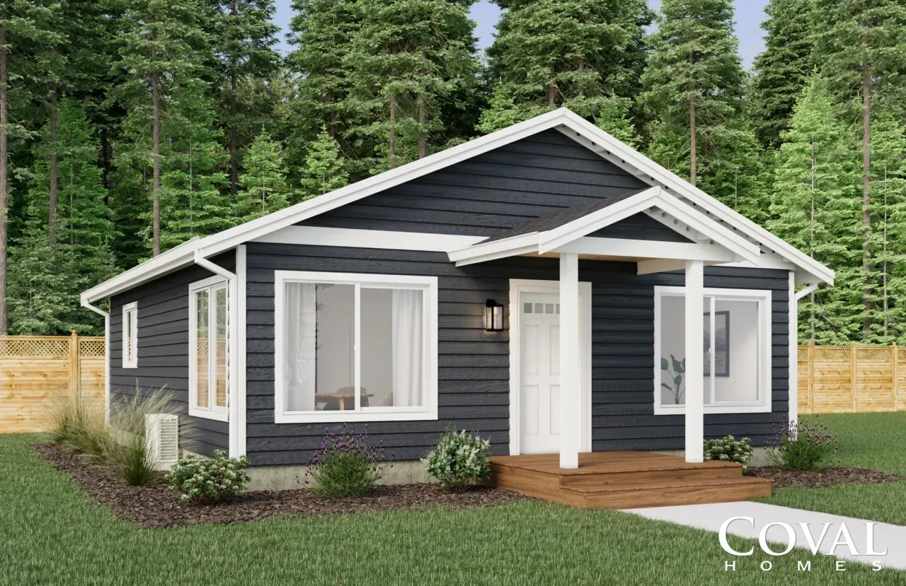 Small gray cottage with white trim, front porch, and large windows in a wooded setting