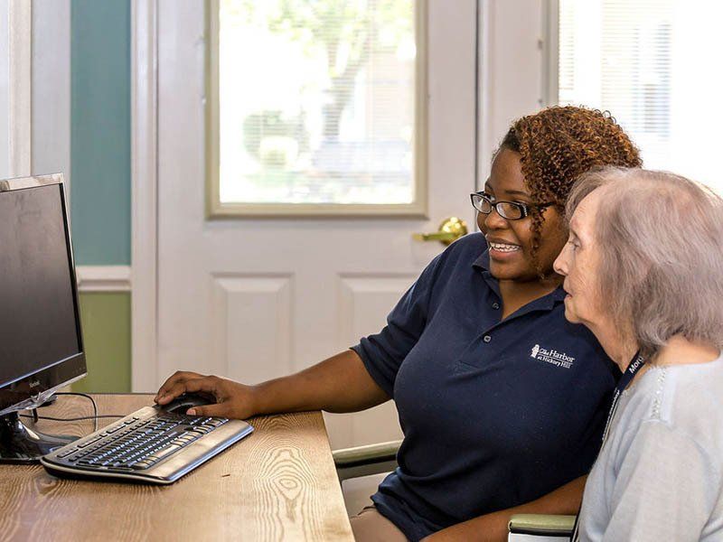 A woman is helping an older woman use a computer.