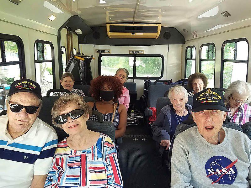 A group of elderly people are sitting on a bus.