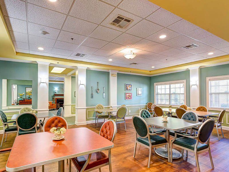 There are many tables and chairs in the room.