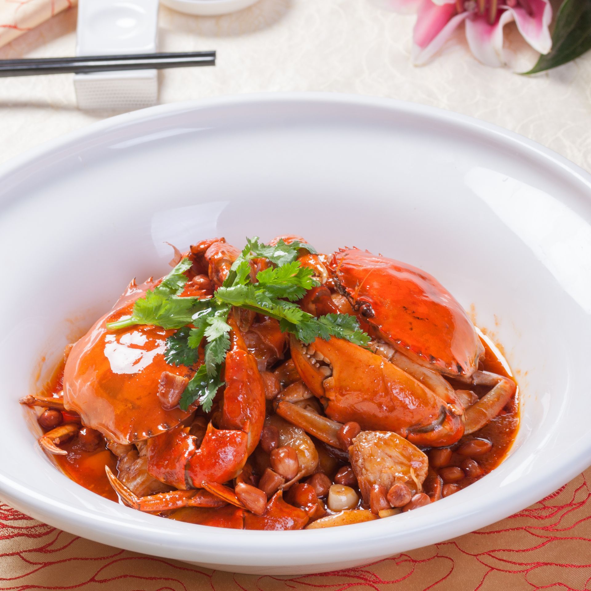 A white bowl filled with crabs and vegetables on a table