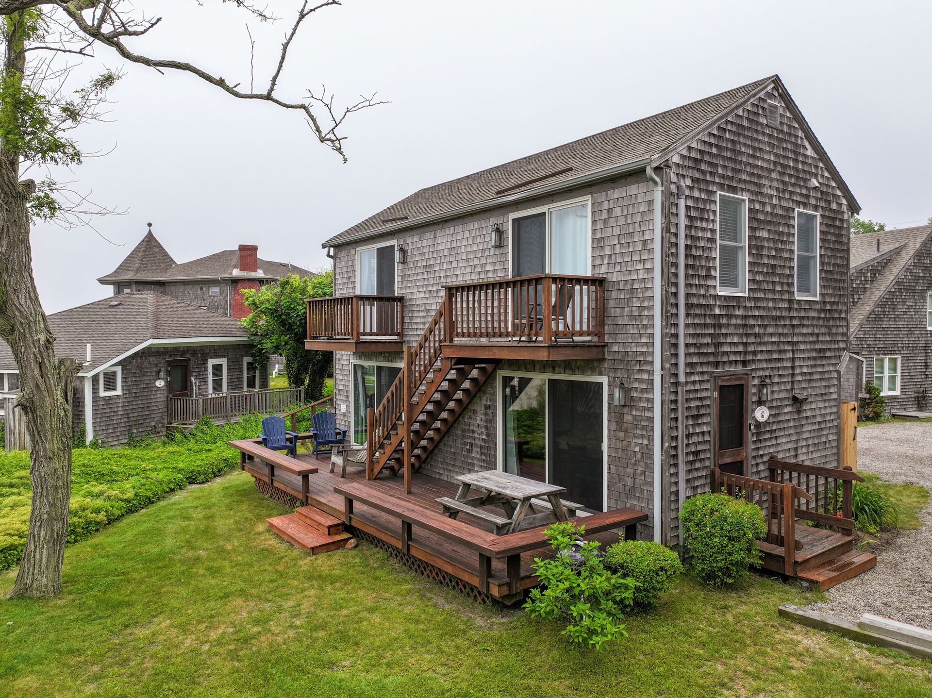 A large brick house with a wooden deck and stairs.