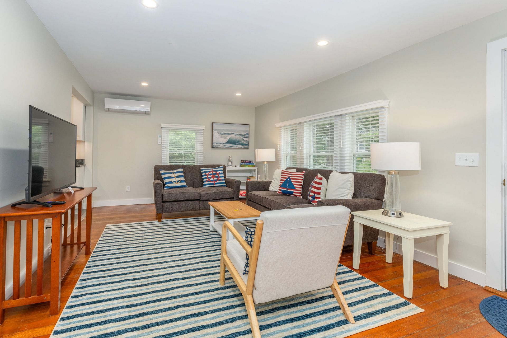 A living room with a couch , chair , table and television.