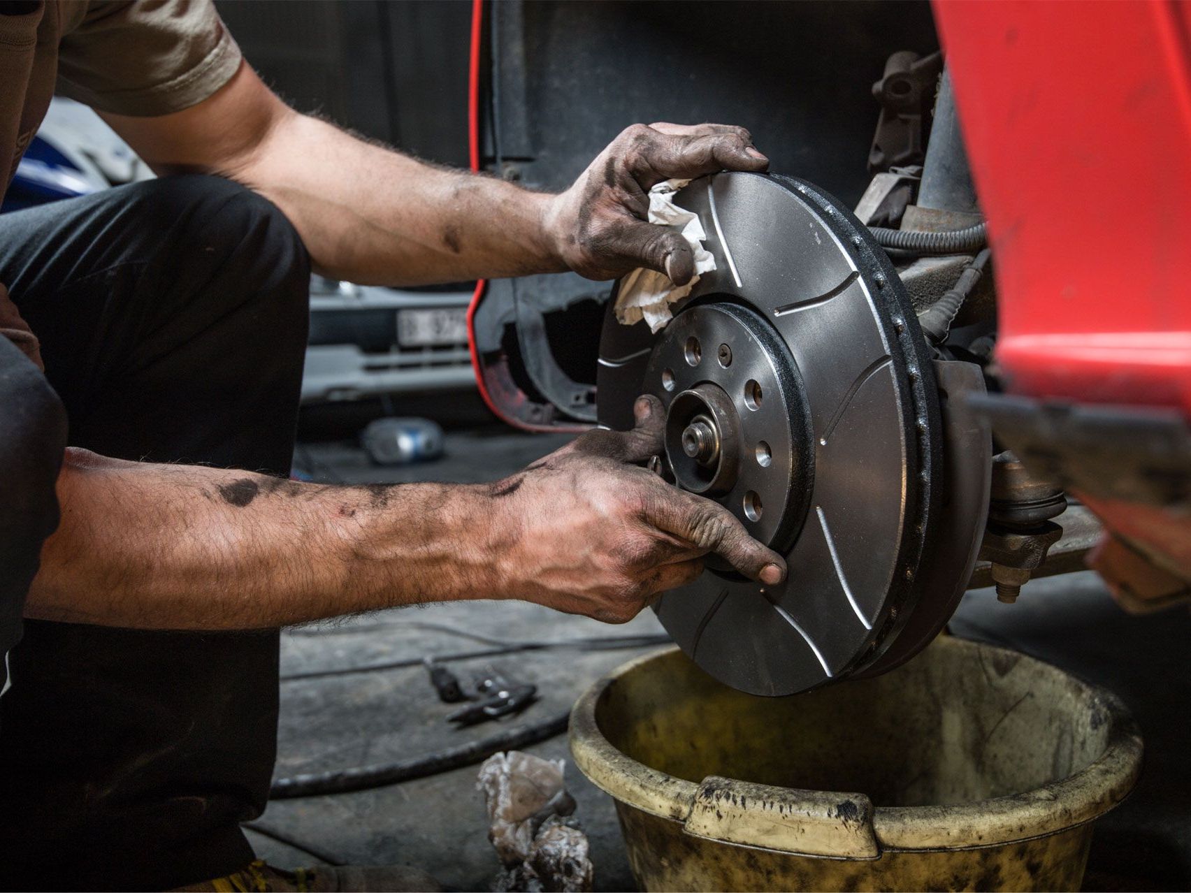 Mechanic changing a car brake rotor | American Muffler & Auto Repair