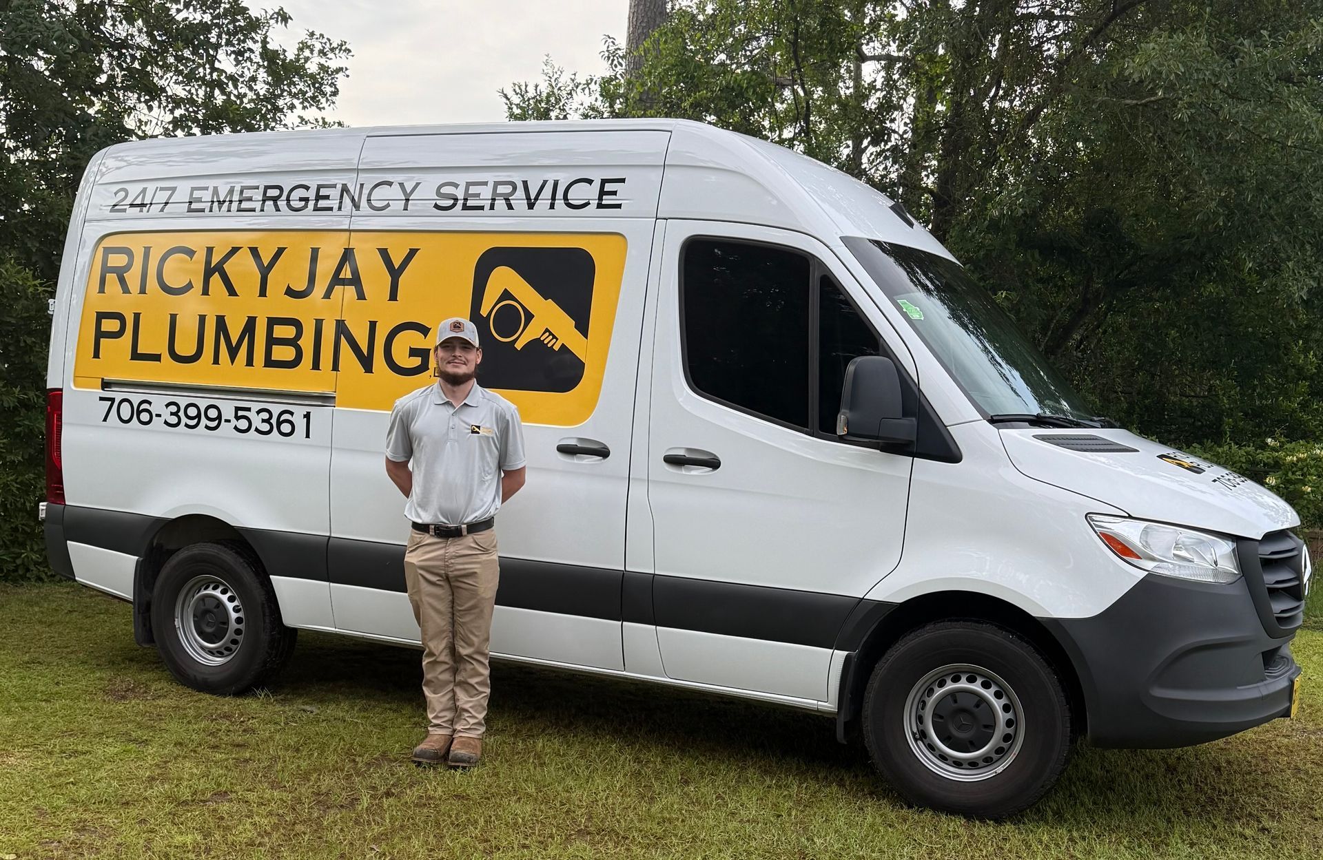 A man is standing in front of a ricky jay plumbing van