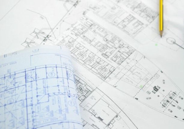 Un lápiz está encima de un plano de un edificio.