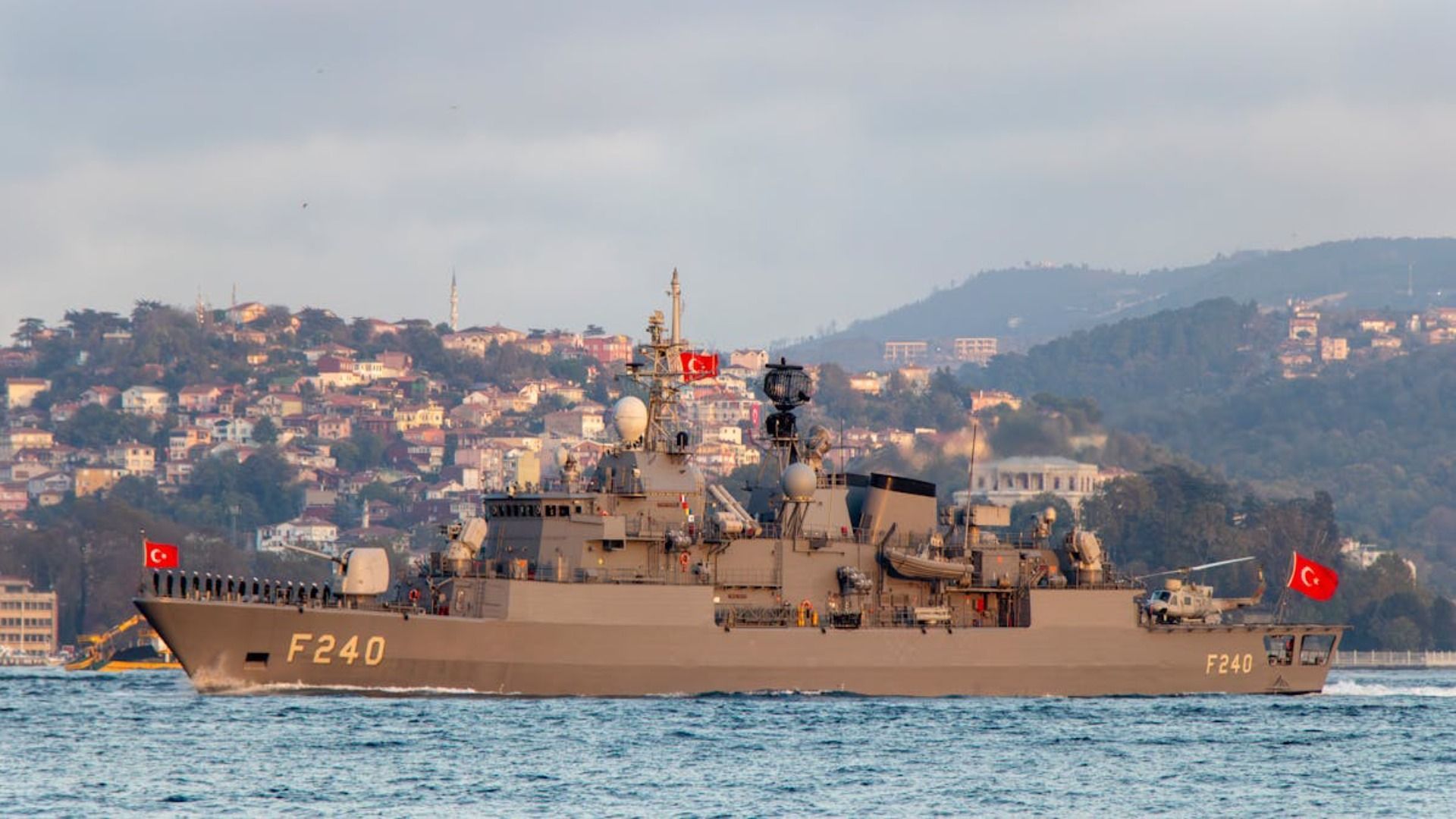 Un gran barco militar flota sobre un cuerpo de agua.