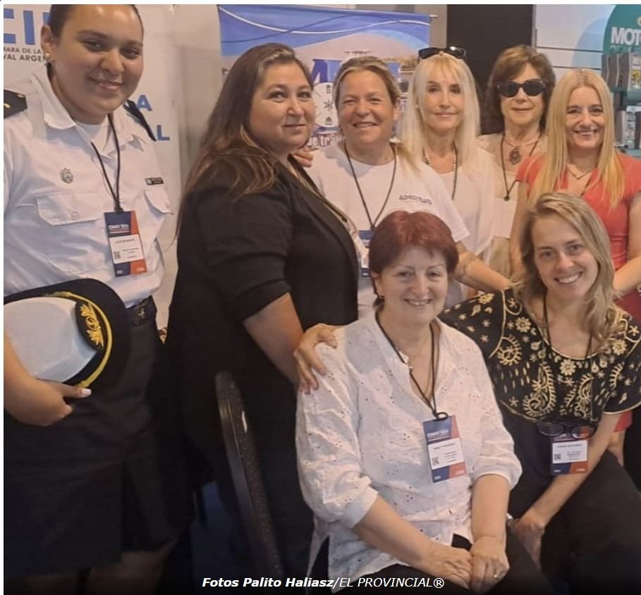 Un grupo de mujeres posa para una foto con un hombre sosteniendo un sombrero.