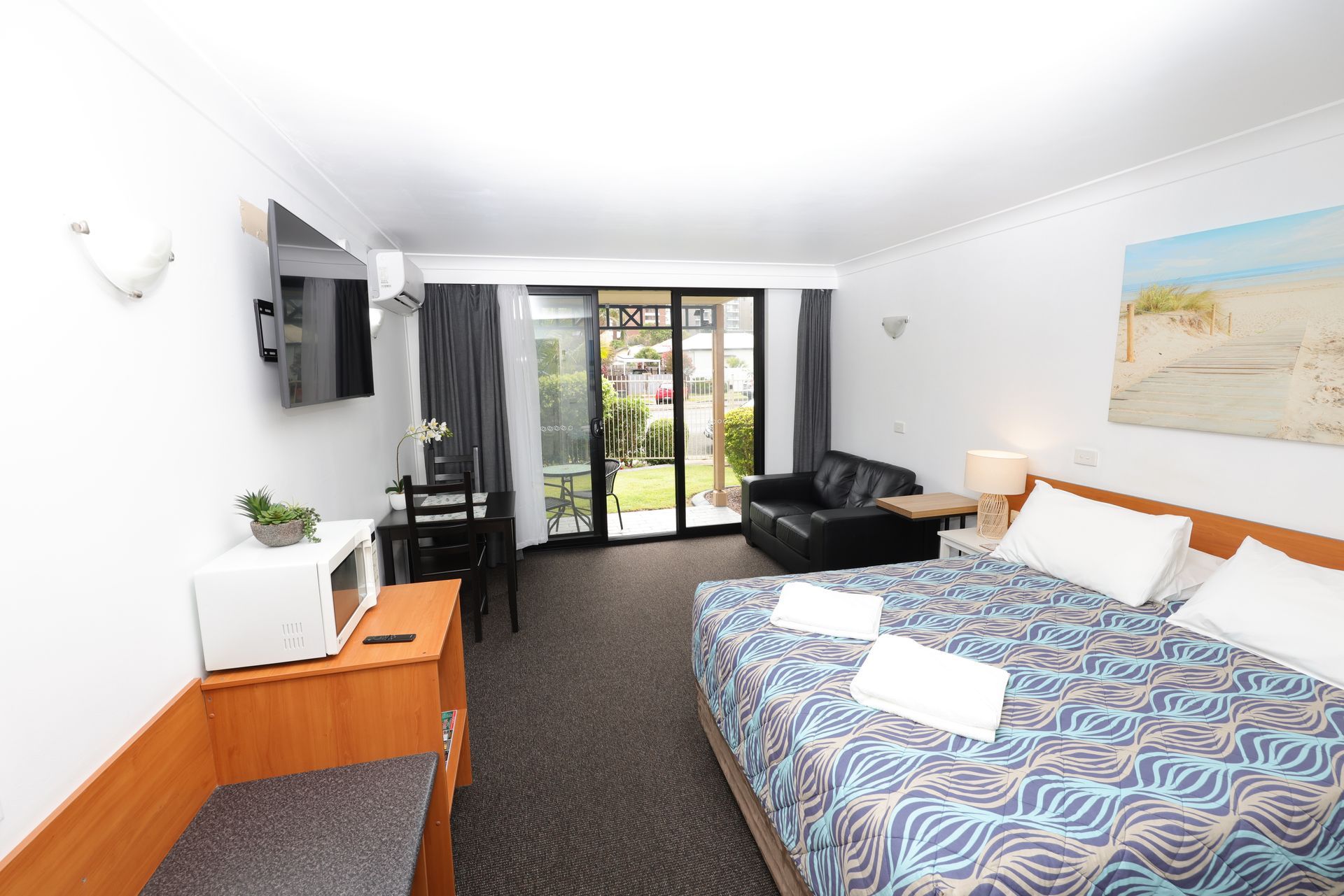 Queen bed with towels. Microwave, TC and view to gardens