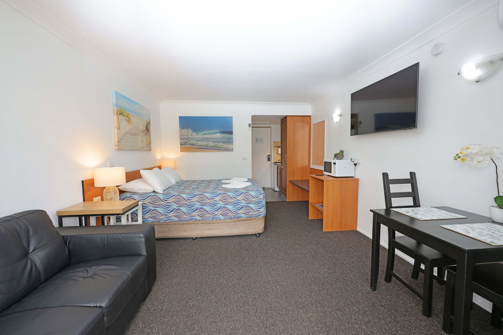 Town Beach Motor Inn room showing lounge, ding table, microwave and bed
