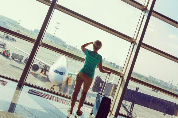 beautiful young woman with blond short hair with a suitcase at the airport and waiting for her flight; Shutterstock ID 224201161; PO: N/A; Job: RDL; Client: N/A; Other: RDL