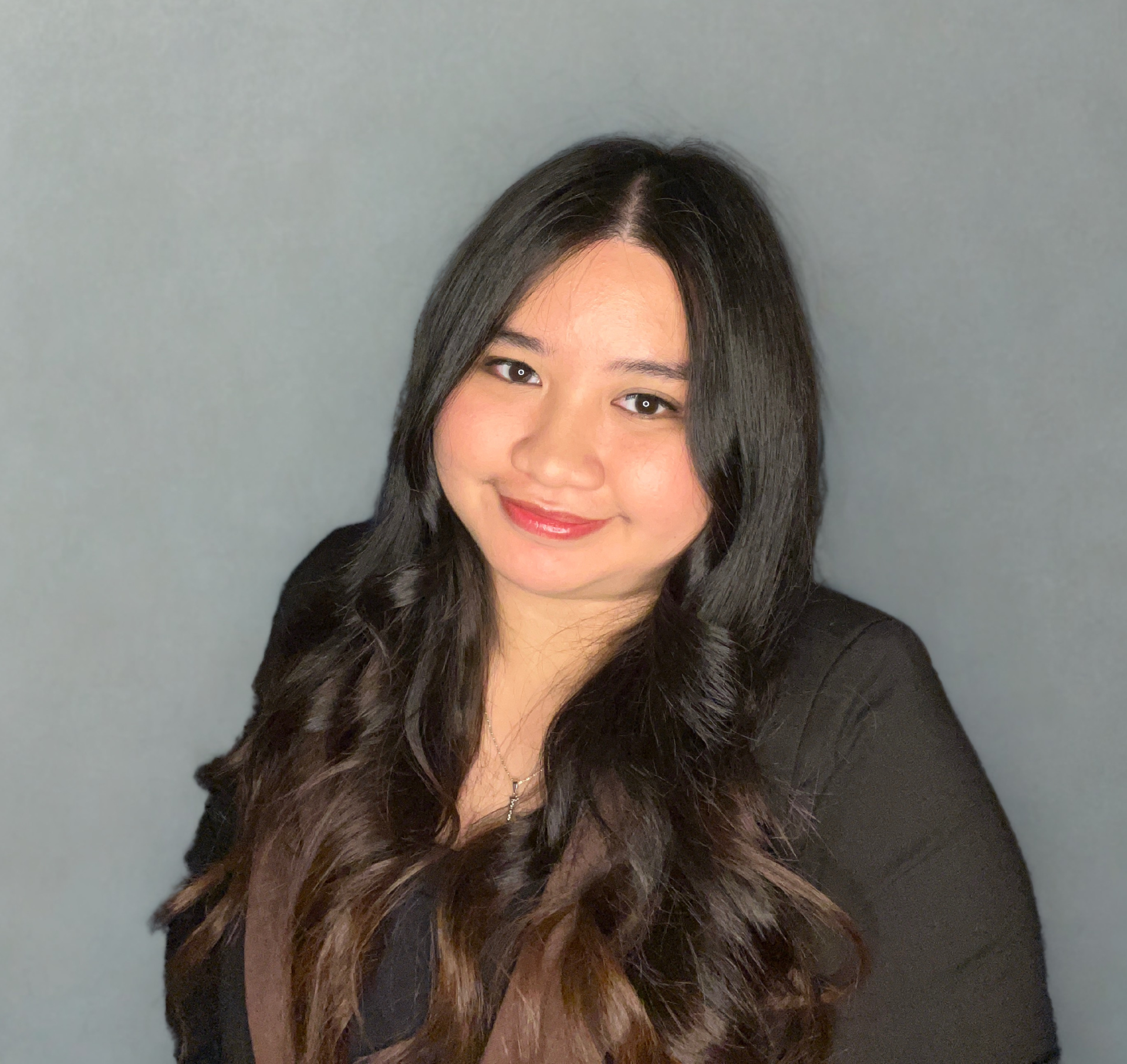 The woman is wearing a black turtleneck and smiling for the camera.