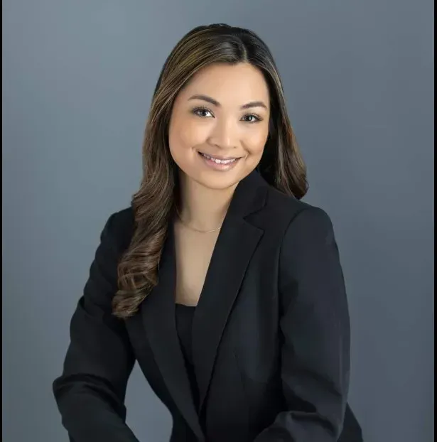The woman is wearing a black jacket and smiling for the camera.