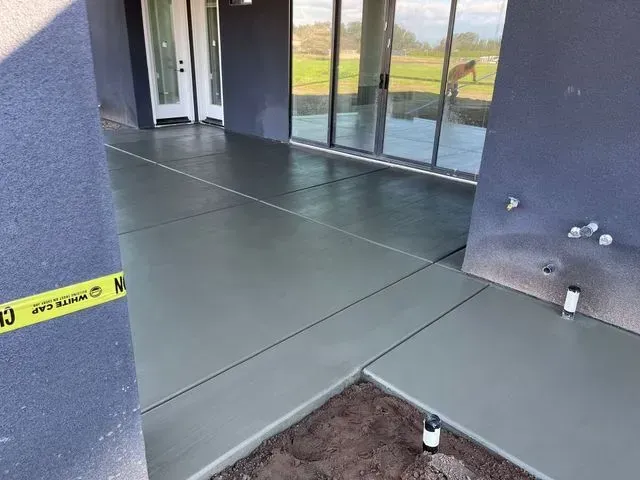 A concrete walkway is being built in front of a house.