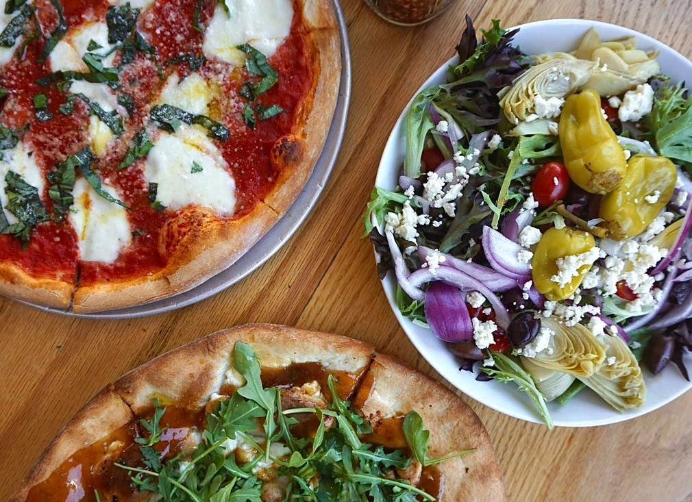 Pizza with toppings and a salad