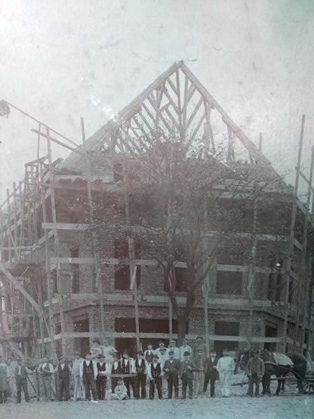 A group of people are standing in front of a building under construction.