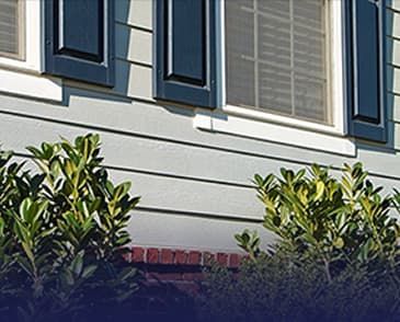 A house with blue shutters and a brick wall