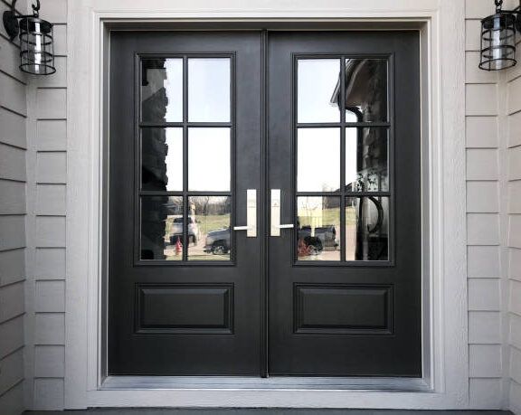 The front door of a house has a reflection of cars in the glass