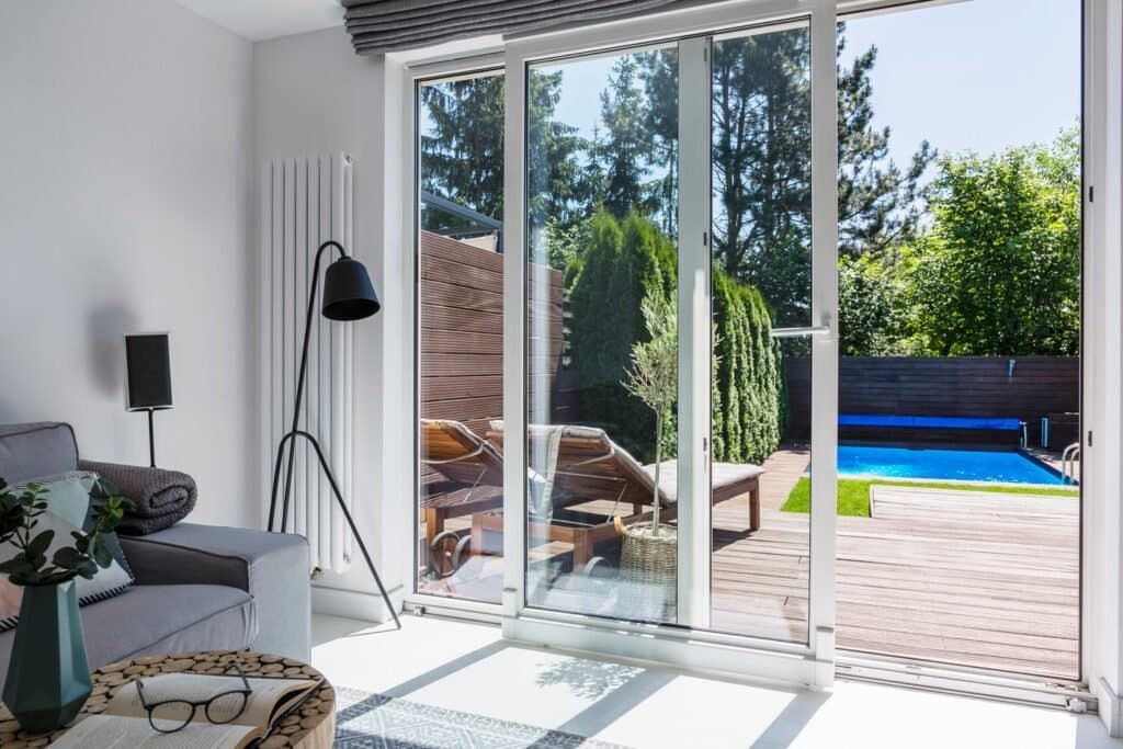 A living room with sliding glass doors leading to a swimming pool.