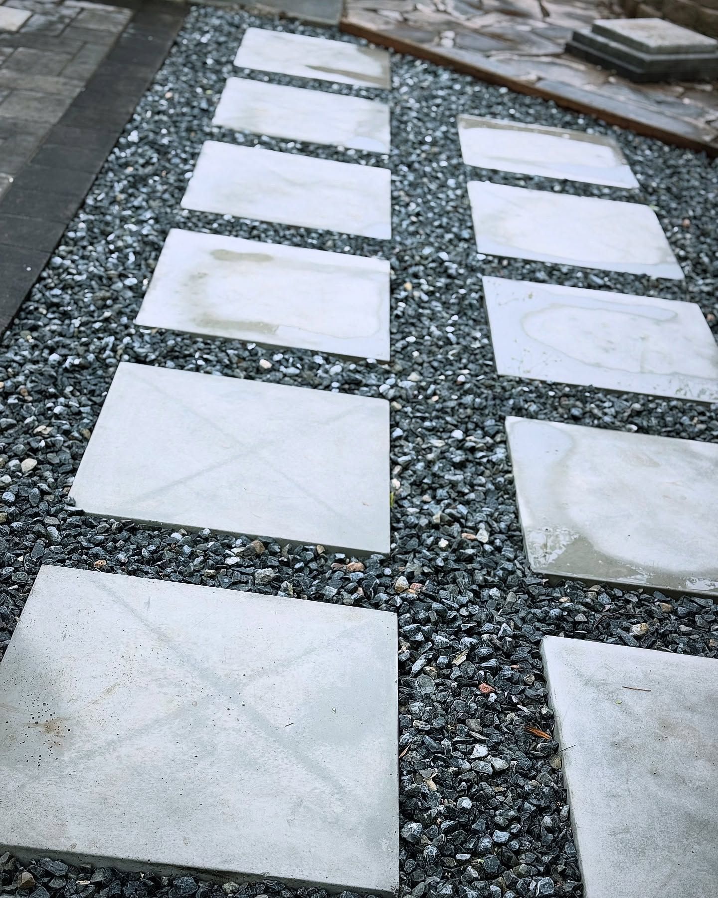 Concrete stepping stones laid in gravel, creating a pathway.