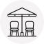 Two chairs under an open umbrella, likely in an outdoor seating area.